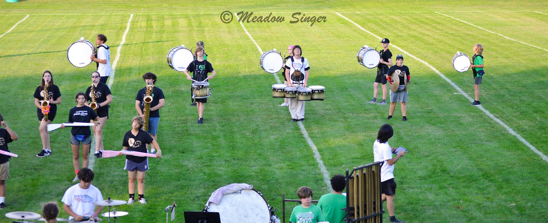 A marching band rehearsing on a football field