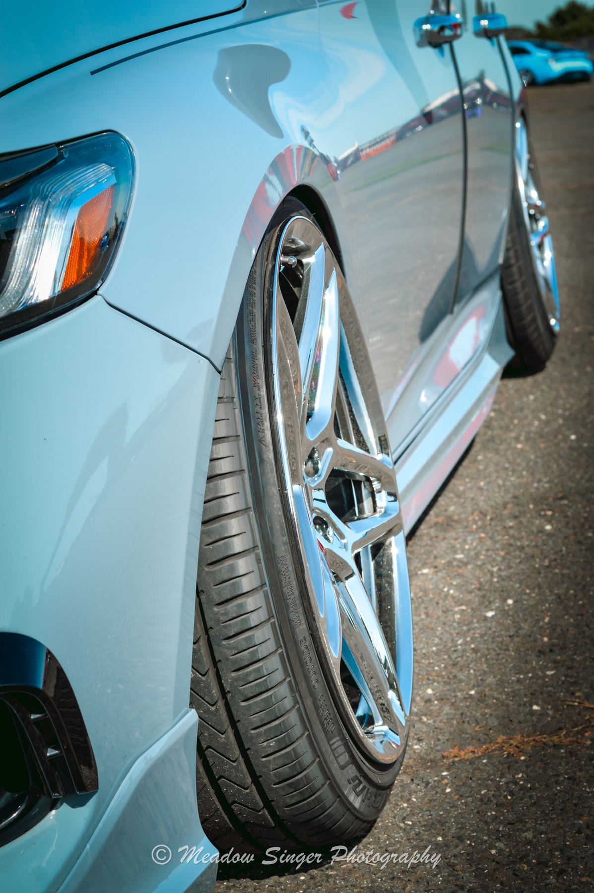 Close up of a polished multi spoke wheel on a lowered silver car