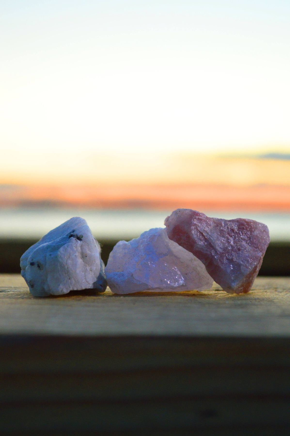 A stack of sea glass on a railing at sunset