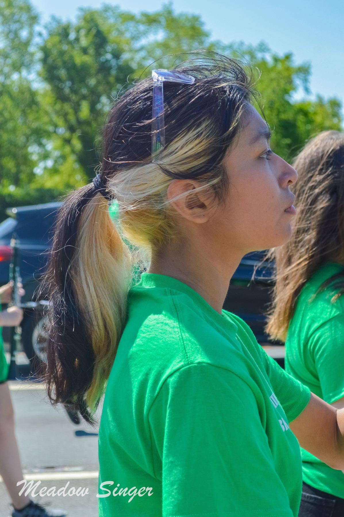 A girl in a green band shirt at a parade
