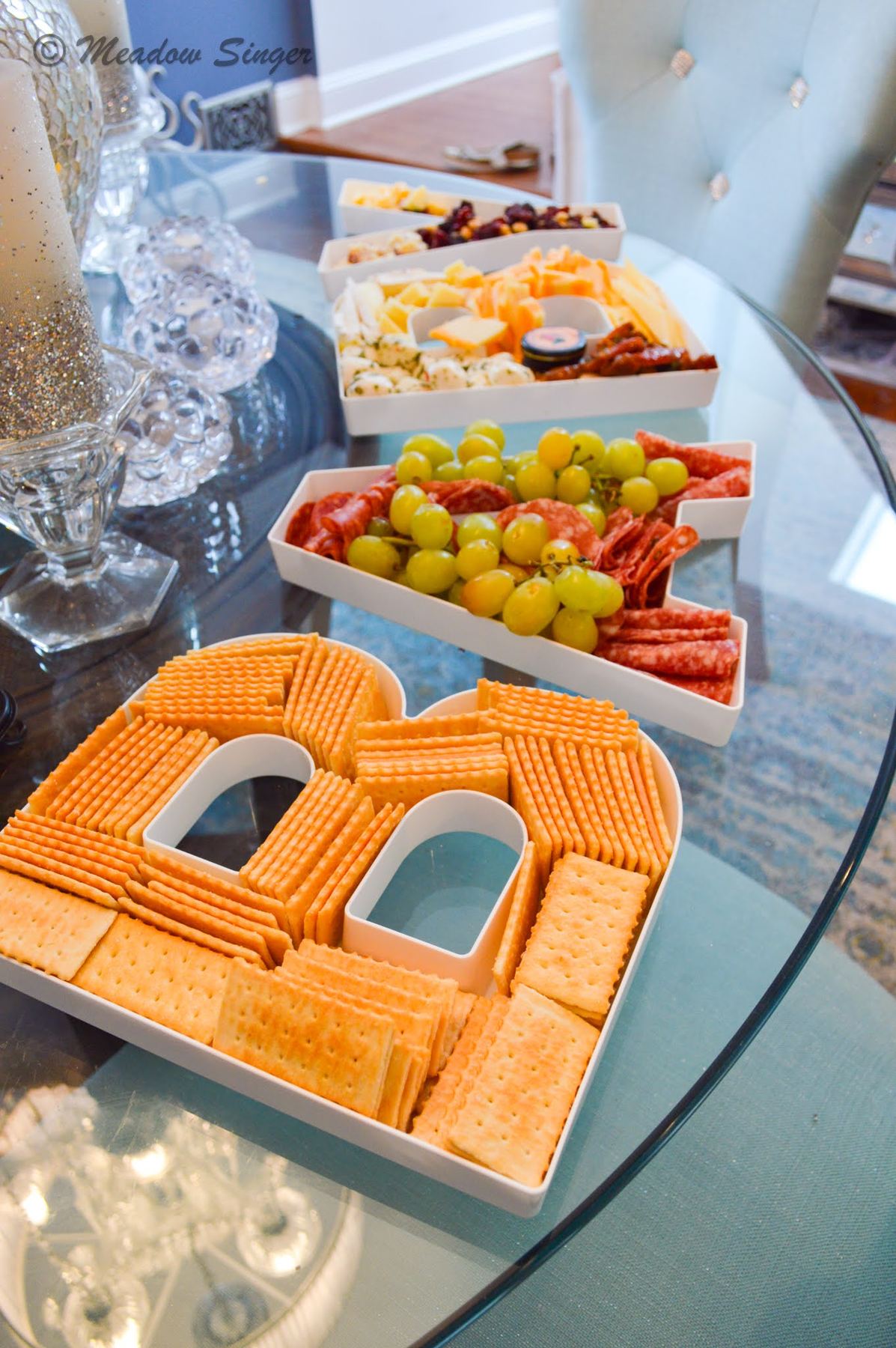 A snack board with crackers laid out in the shape of a letter B